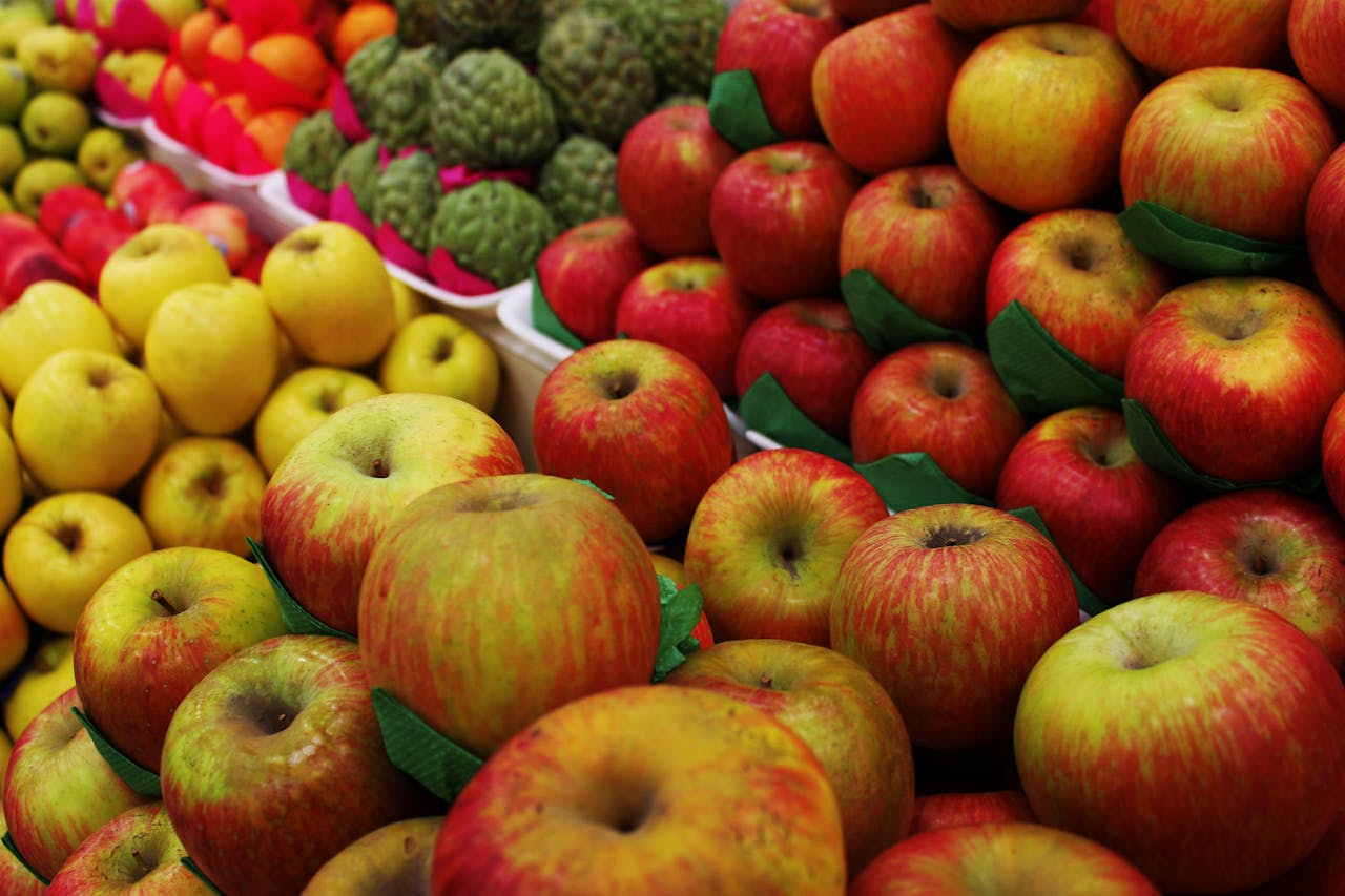 contact-img Colorful arrangement of fresh apples on market display, showcasing vibrant red and yellow hues.